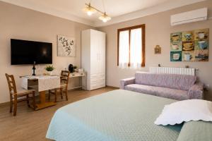 a living room with a bed a couch and a table at Villa Mandrioli in Cecina