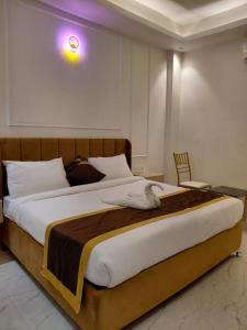 a bedroom with a large bed with a light on the wall at Ravira Resort in Sītāpur +52 photos