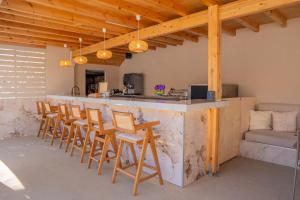 a kitchen with a bar with wooden stools at St Constantin Sea Hotel & Spa Resort in Gouves