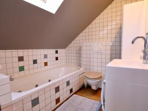 a bathroom with a tub and a toilet and a sink at Cocoon in Houffalize +31 photos