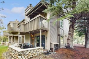 a large house with a balcony and a tree at Snowcreek 1520 in Sun Valley