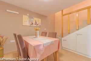 a dining room table with chairs and a vase of flowers on it at Milena Sea & Mountain View in Zubovići