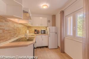 a kitchen with a white refrigerator and a window at Milena Sea & Mountain View in Zubovići +18 photos