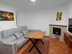 a living room with a couch and a table at Casa La Piedra in Constantina
