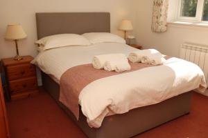 a bedroom with a bed with two towels on it at Eastwood Cottage in Turriff