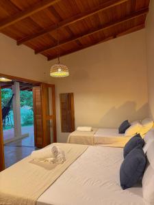 a bedroom with two beds and a chandelier at Casa do Rio Âmbar - Alter do Chão in Santarém