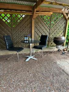 ein Grill, zwei Stühle, ein Tisch und ein Grill in der Unterkunft Ribevej 12 in Egebæk