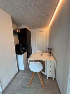 ein kleines Zimmer mit einem Schreibtisch und einem weißen Stuhl in der Unterkunft Ribevej 12 in Egebæk