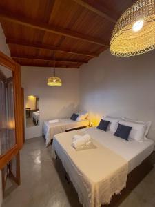 a bedroom with two beds and a chandelier at Casa do Rio Âmbar - Alter do Chão in Santarém +11 photos