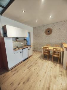 a kitchen with white cabinets and a wooden table at L'atelier in Verviers