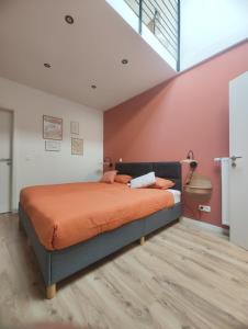 a bedroom with a bed with an orange blanket at L'atelier in Verviers +11 photos