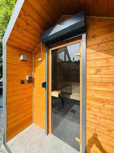 an outside door of a wooden house with a porch at Wilcza Osada Wellness Resort in Wilcza