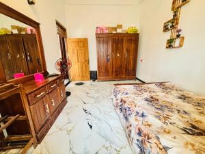 a bedroom with a bed and some wooden cabinets at Ima Manazil homestay in Kalpitiya