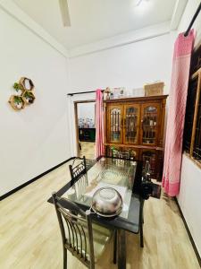 a dining room with a glass table and chairs at Ima Manazil homestay in Kalpitiya