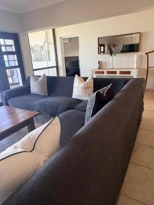 a living room with two blue couches and a table at 3 Bedroom - Salt Rock Beach Pad in Ballito