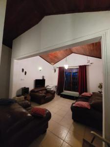 a living room with leather couches and a large window at Riverston view hostel in Matale