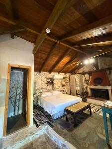 a bedroom with a large bed and a fireplace at Sparta Gaia Retreat in Áyios Dhimítrios