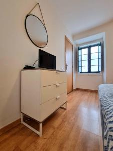 a bedroom with a dresser with a mirror on it at Casa da Anunciada | Old Town in Setúbal