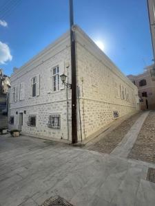 a large white brick building on a street at Casa Amore in Ermoupoli