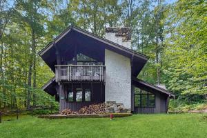 a house with a wrap around porch and a balcony at Hawk House in Killington