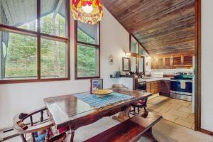 a dining room with a table and a kitchen at Hawk House in Killington