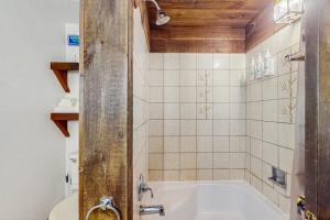 a bathroom with a tub and a toilet in it at Hawk House in Killington +42 photos