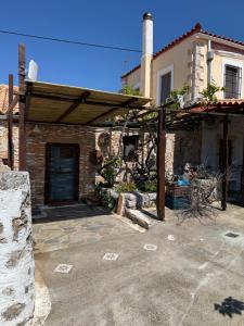 a stone house with a wooden roof and a garage at Sparta Gaia Retreat in Áyios Dhimítrios