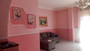 a living room with a couch and a pink wall at Casa Dolce Armonia in Augusta