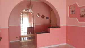 a room with a pink wall and an archway at Casa Dolce Armonia in Augusta