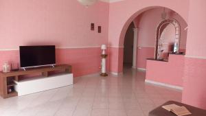 a living room with pink walls and a flat screen tv at Casa Dolce Armonia in Augusta +16 photos
