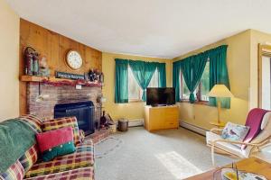a living room with a couch and a fireplace at Kettle Brook A6 in Ludlow