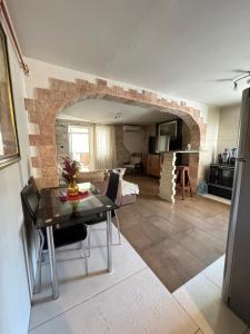 eine Küche und ein Wohnzimmer mit einem Tisch und einem Torbogen in der Unterkunft Vila Aura in Podgorica