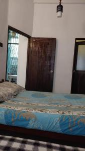 a bedroom with a bed with a wooden door at Riverston view hostel in Matale +19 photos