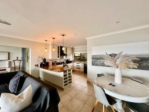 a living room with a table and a kitchen at 3 Bedroom - Salt Rock Beach Pad in Ballito