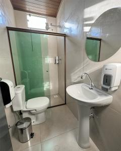 a bathroom with a toilet and a sink and a mirror at Suítes no centro de Bonito, Bonito Brasil Turismo in Bonito +11 photos