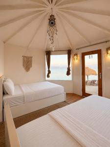 two beds in a room with a view of the ocean at Nour camp in Nuweiba