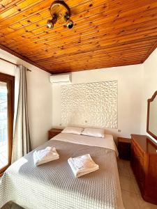 a bedroom with a bed and a wooden ceiling at Lena Apartments 4 in Potos