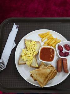 a tray with a plate of breakfast food with toast and fruit at Atlantis De Maria Hotels in Akure