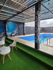 a rendering of a pool with chairs and a table at Atlantis De Maria Hotels in Akure
