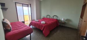 a bedroom with a red bed and a couch at Eremare Marinella in Marinella di Sarzana