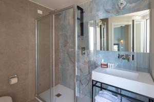 a bathroom with a sink and a shower at Acciuga Hotel in Laigueglia +57 photos