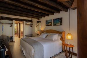 a bedroom with a white bed and a wooden ceiling at Pousada Maravilha in Fernando de Noronha +208 photos