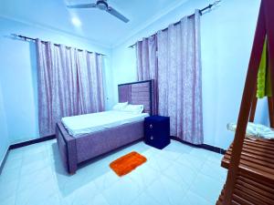 a bedroom with a bed and a window with curtains at Zanzibar Apartment 1 in Kibele