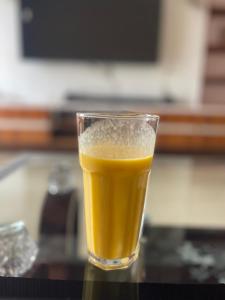 a glass of orange juice sitting on a table at KIGALI FANTASTIC Aparthotel in Kigali