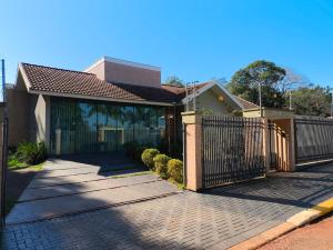a house with a fence and a brick driveway at Espaço MGS in Foz do Iguaçu