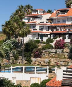 a large white building on a hill with palm trees at Le Casa del Sol de Marta in Manilva