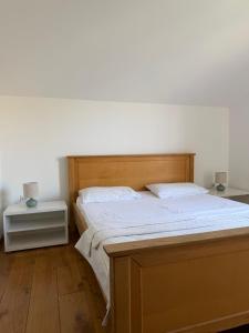 a bedroom with a bed with a wooden headboard at Novia Apartment 22 in Đenovići