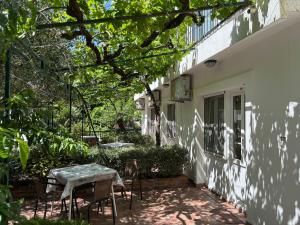 a patio with a table and chairs next to a building at Vila Stanisic in Čanj
