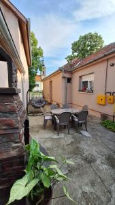 a patio with a table and chairs next to a building at Veslo IN in Krčedin