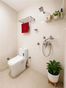 a bathroom with a toilet and a shower and a plant at RK Homes in Delhi